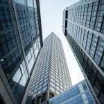 vertical low angle shot of high rise skyscrapers in a glass facade in frankfurt, germany
